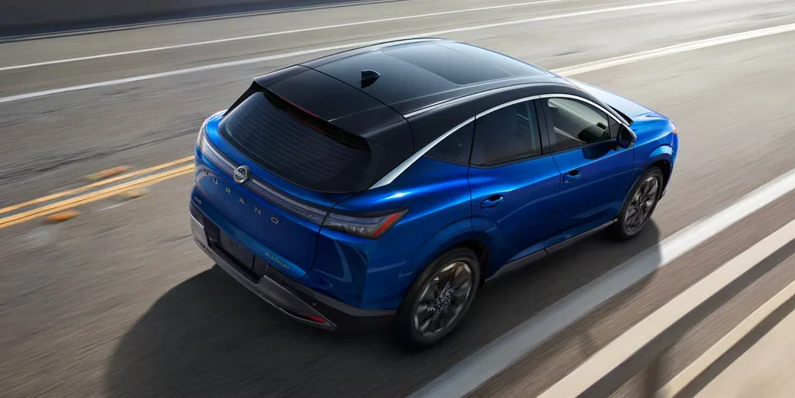 A blue 2025 Nissan Murano driving down the road.