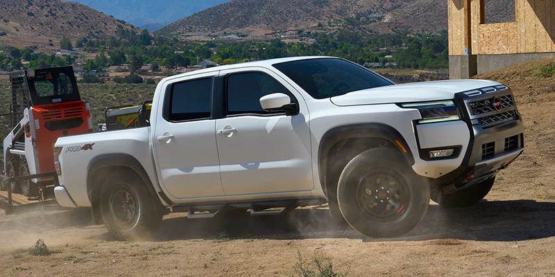 White 2026 Nissan Frontier in Towing a luggage picker